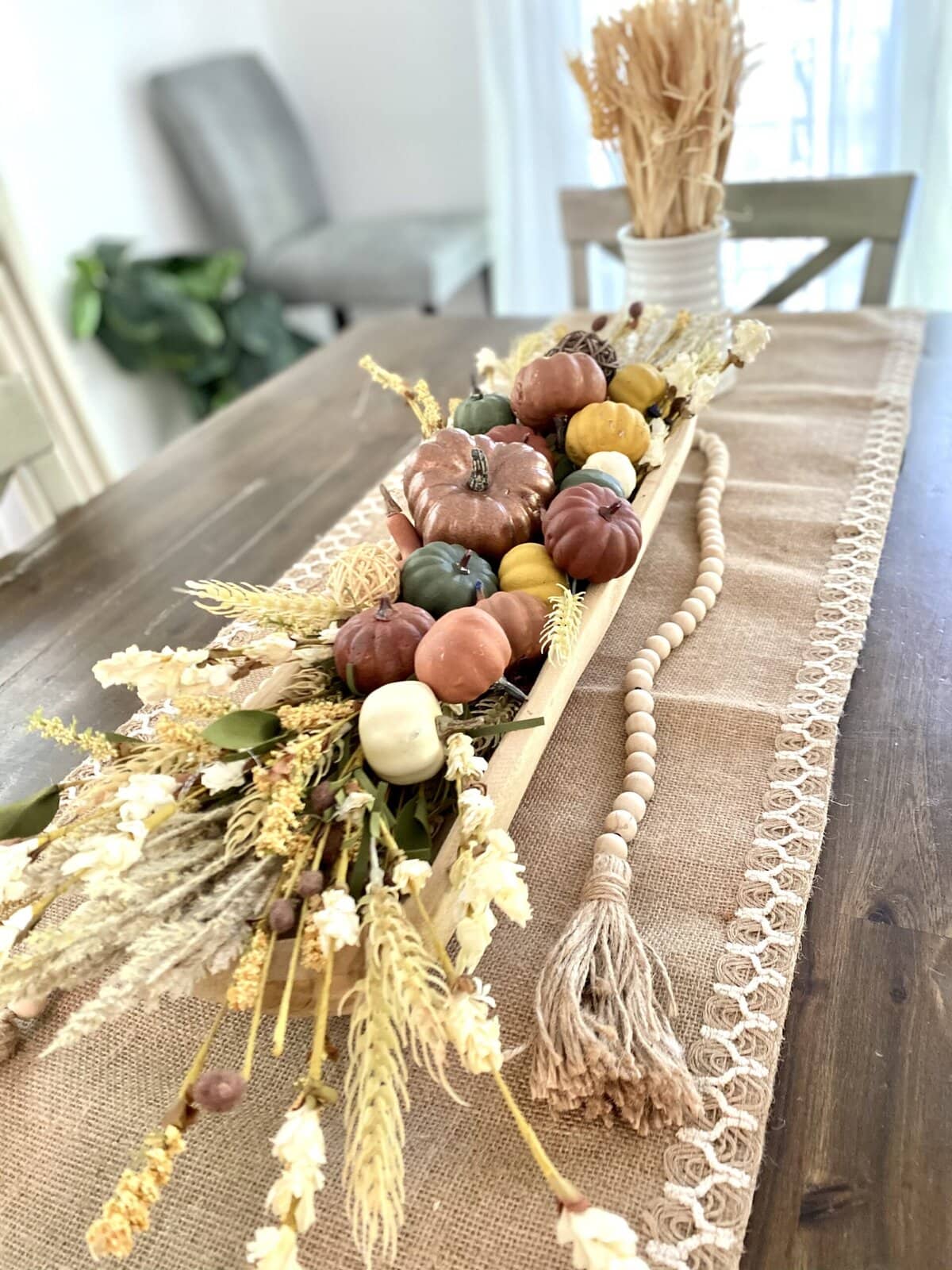 Delicate dried flower arrangements on rustic wooden shelves with inspirational quotes, creating a cozy and elegant home decor setup.