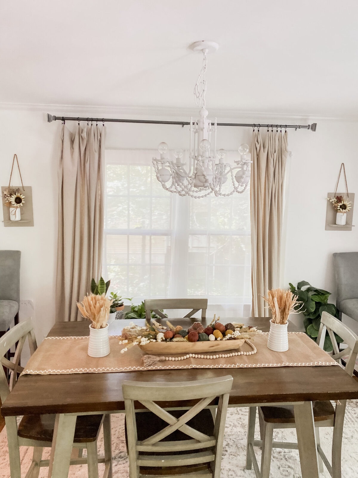 Cozy living room with brown leather sofa, rustic wooden accents, and decorative autumn-themed vases, creating a warm and inviting home interior atmosphere.