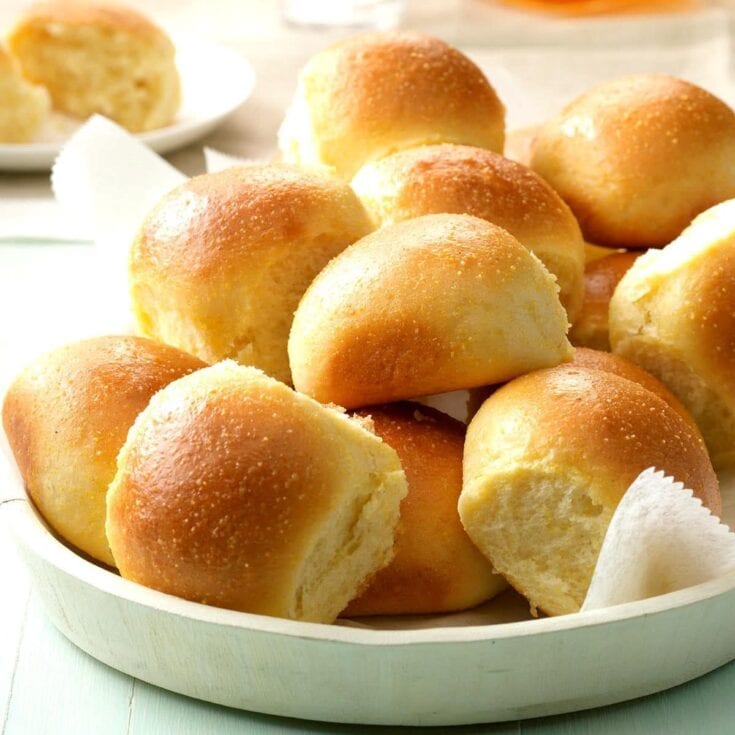 Fluffy homemade dinner rolls with golden crust served in a white bowl, perfect for comfort food and family gatherings.
