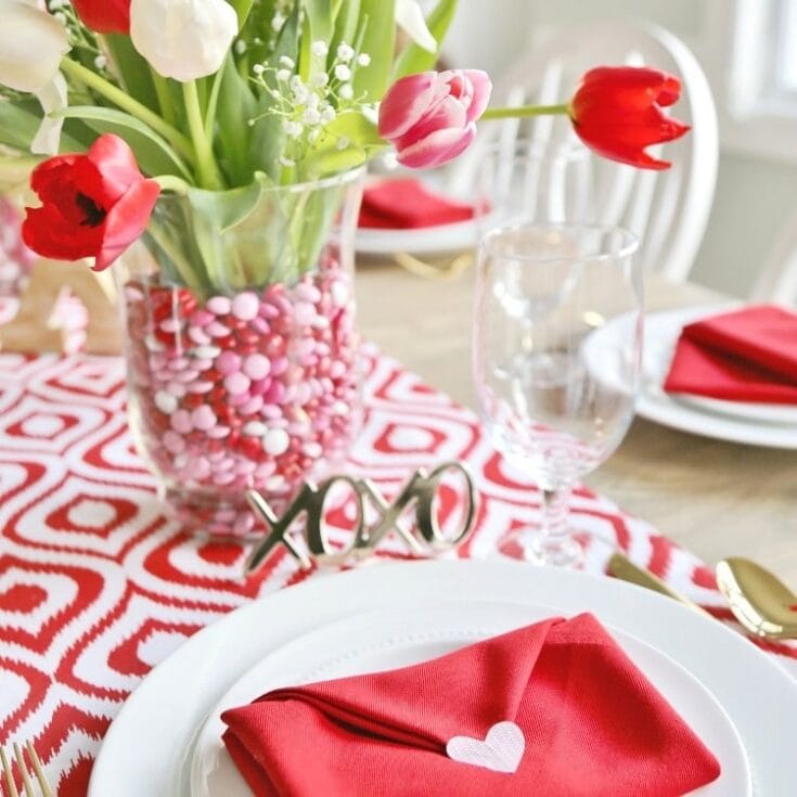Roses tulips Valentine's Day table centerpiece with pink and red decor elegant floral arrangement for romantic celebrations.