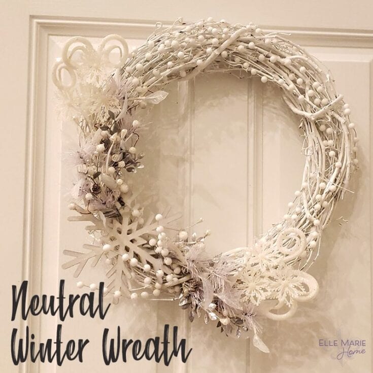 White winter wreath with snowflake and berry decorations for neutral holiday décor. Perfect for Christmas or winter home accents, creating a cozy, festive atmosphere.