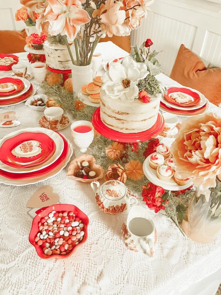 Beautiful Valentine's Day dessert table with cake, cupcakes, chocolates, and flowers for romantic celebration. Perfect for intimate gatherings and love-themed parties.