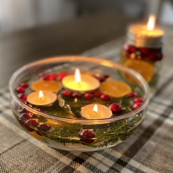Red and orange floating candles and berries in glass bowl, cozy autumn home decor, warm ambiance, aromatherapy, seasonal decorations for fall or winter, handmade aesthetic, festive table centerpiece.
