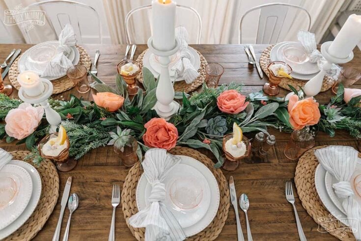 Elegant rustic table setting with floral centerpiece, candles, and coordinated dinnerware for outdoor wedding or dinner party. Perfect for boho-chic, summer, or spring celebrations.