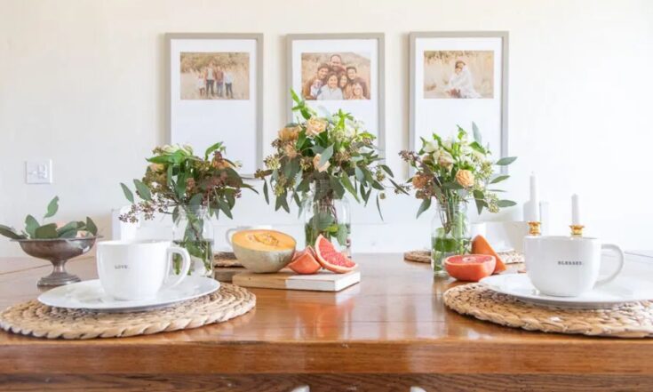 Fresh floral table centerpiece with vases and candles for spring or summer decor, highlighting home styling, elegant table setting, and cozy seasonal ambiance.