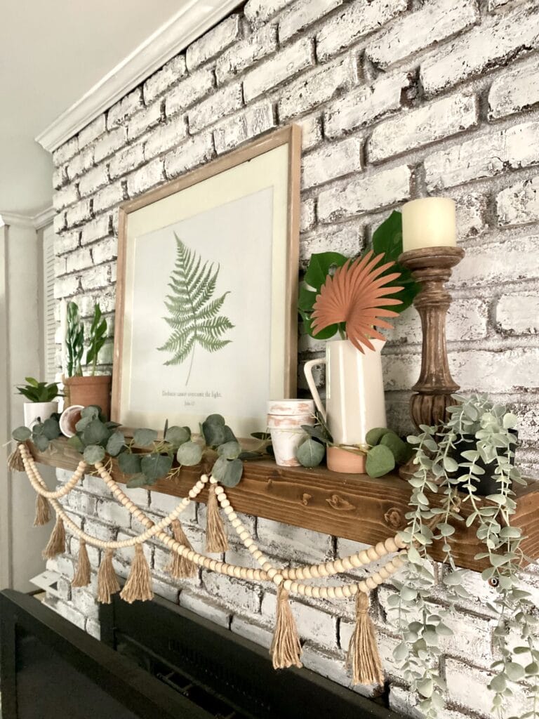 Cozy living room with neutral tones, wooden accents, and greenery, showcasing stylish wall decor and a comfortable beige sofa. Perfect for creating a warm, inviting home atmosphere.