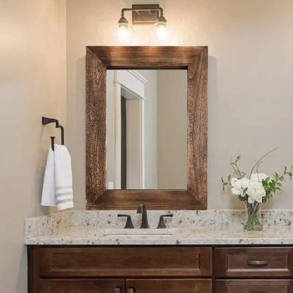 Bright bathroom vanity with a rustic wooden framed mirror, modern black faucet, white marble countertop, and fresh white floral arrangement for elegant bathroom decor.
