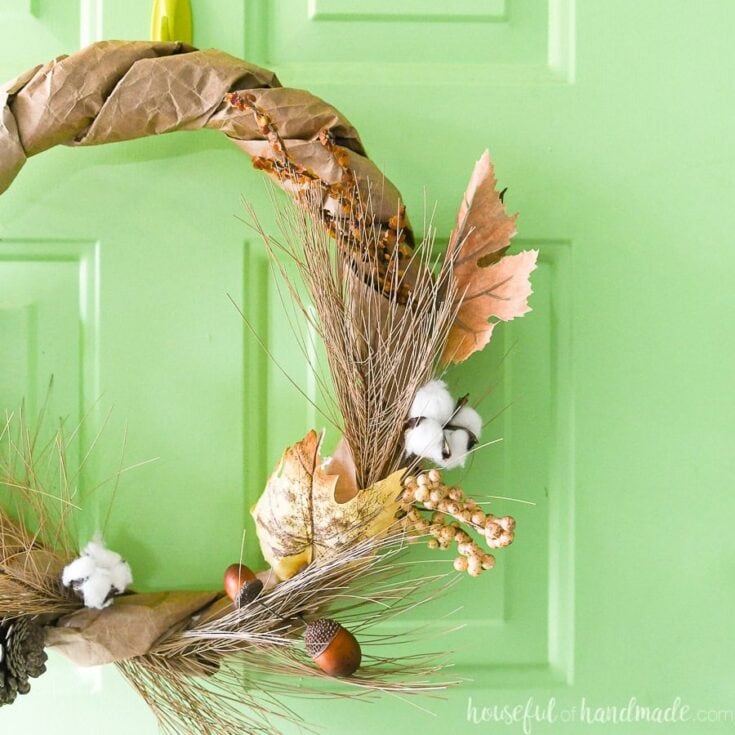 Goldenfall autumn wreath with dried leaves, pinecones, cotton branches, and berries for cozy fall decor – perfect for handling seasonal decorations and fall home accents.