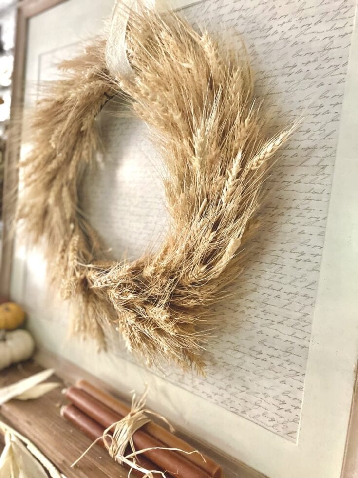 Golden wheat wreath decor with a natural, rustic touch for home or event decoration, featuring dried wheat stalks arranged in a circular shape on a handwritten script background.