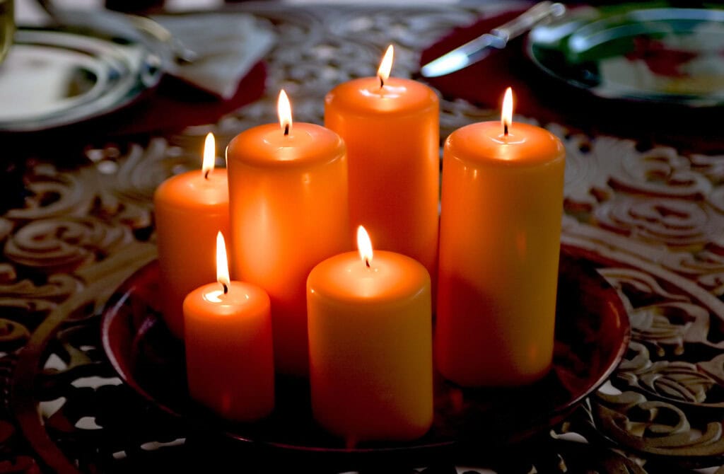 Soft glowing orange candles on a decorative tray, creating a warm and cozy ambiance for home decor or romantic occasions.
