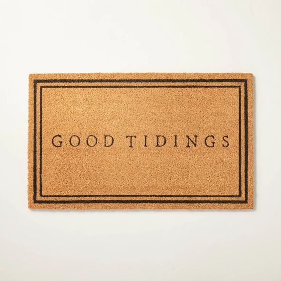 Soft welcome mat with the phrase "Good Tidings" in minimal black font, perfect for a warm holiday or seasonal home decor.