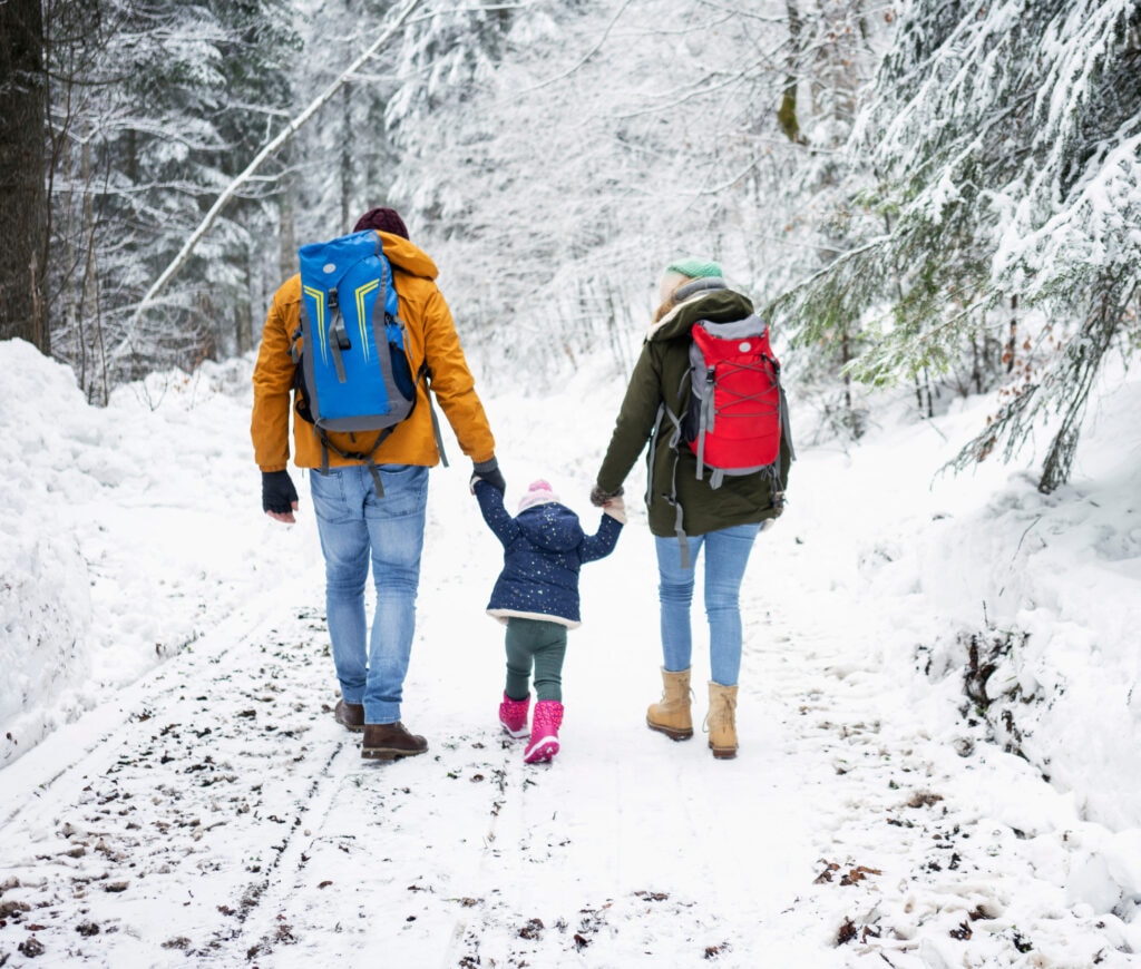 family walking in snow for winter photo shoot