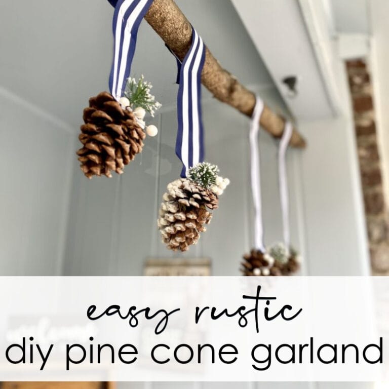Pine cone rustic holiday garland with blue and white striped ribbons and festive sprigs hanging from a wooden rod, perfect for DIY seasonal decoration.
