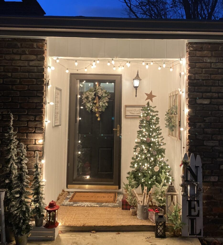christmas porch with tree, candles, flocked pine trees for rustic christmas home decor