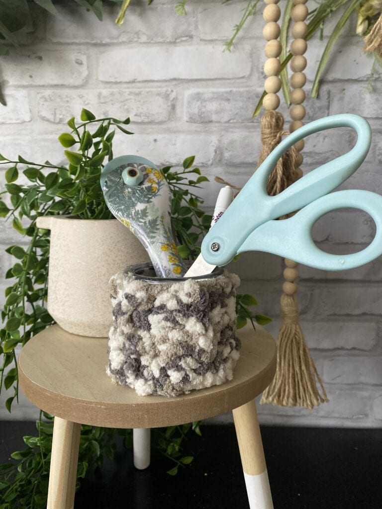 yogurt jar with crochet cover filled with office supplies