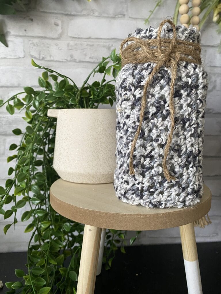 grey crocheted cover on jar on stand