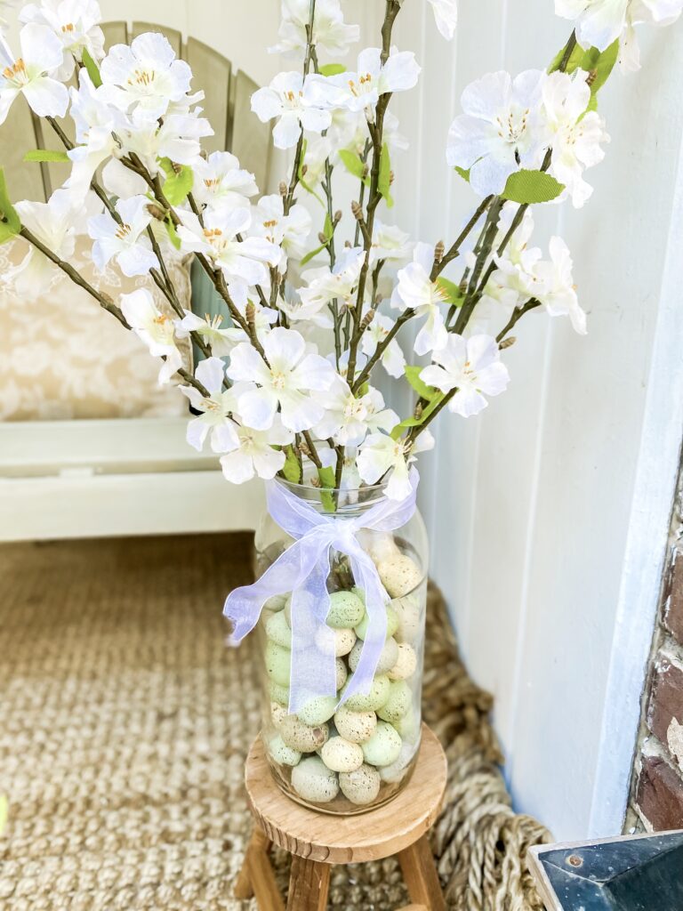 vase filled with eggs and easter flower blossoms for rustic easter porch