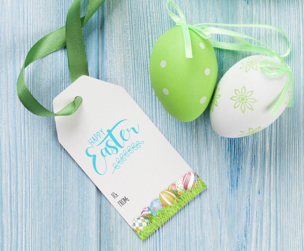 Bright green and white Easter eggs decorated with floral and polka dot patterns, along with a "Happy Easter" gift tag, on a light blue wooden background.