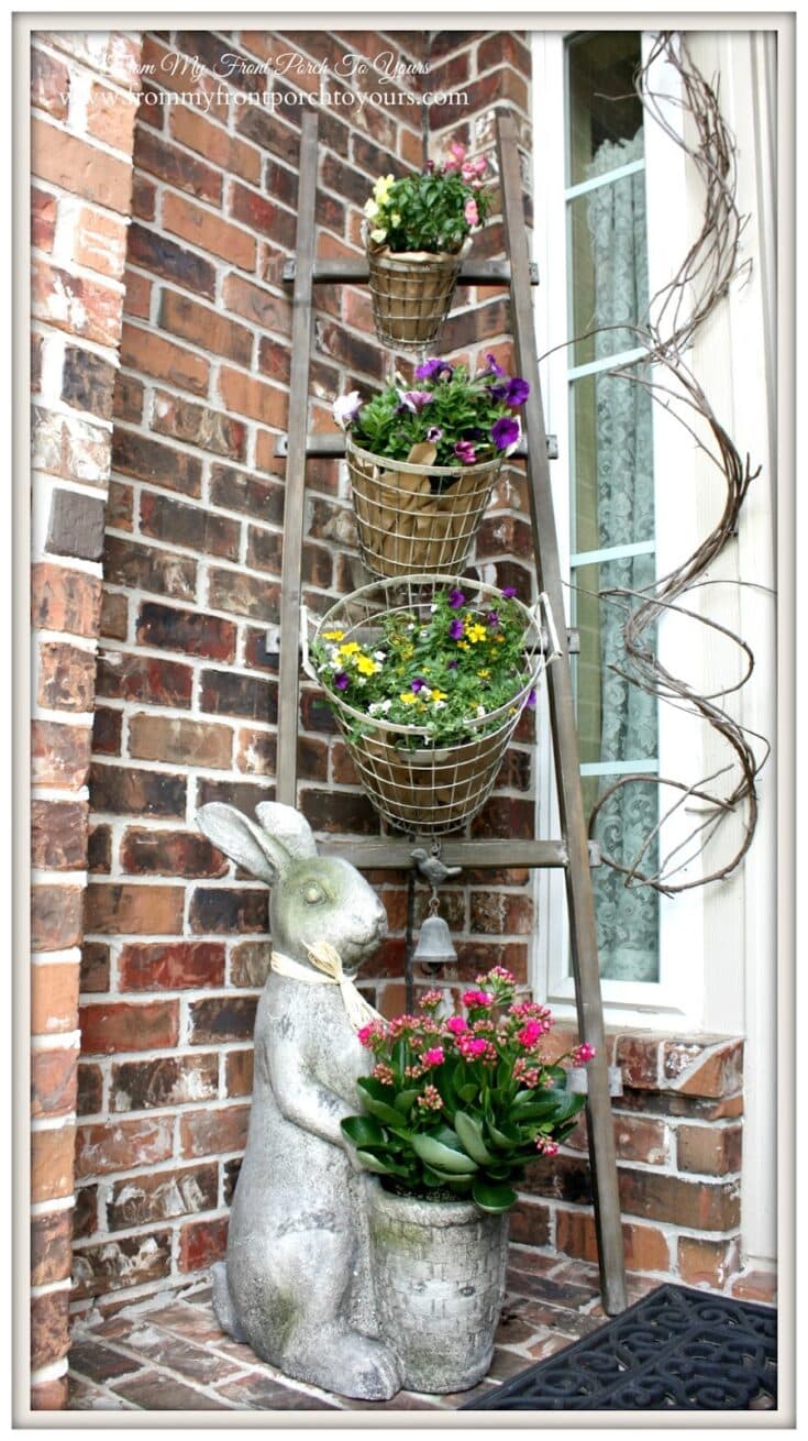 Bright outdoor planters with blooming flowers arranged on a rustic ladder against a brick wall, creating a charming garden display. Ideal for enhancing curb appeal and outdoor decor.
