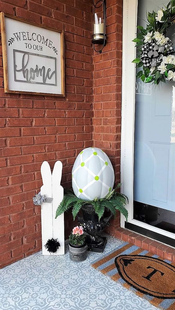 Welcome decor with Easter-themed elements, including a decorative bunny, a large egg ornament with green and white patterns, and welcoming home signage. Perfect for spring and Easter celebrations.