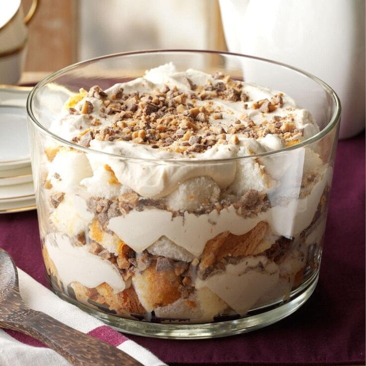 Layered tiramisu dessert with creamy mascarpone, coffee-soaked ladyfingers, and sprinkled chocolate chips in a clear glass trifle dish. Perfect for special occasions and indulgent desserts.