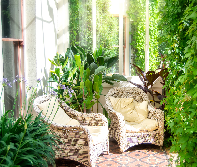 wicker chairs on patio with plants and bushes for privacy