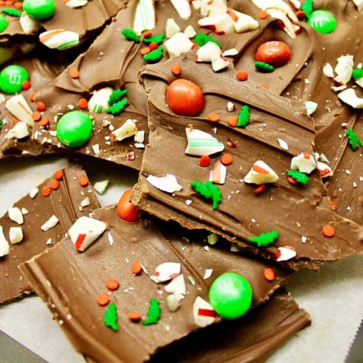 Chocolate bark with holiday sprinkles, candy canes, and colorful chocolate pieces for festive treats and seasonal celebrations.