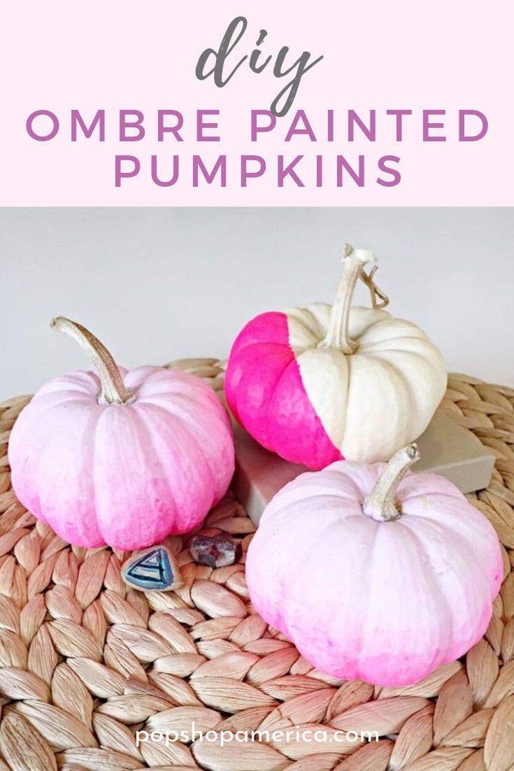 Colorful ombre painted pumpkins in pink and white shades, perfect for fall decorations, displayed on a woven surface with a soft pink background, ideal for autumn home decor.