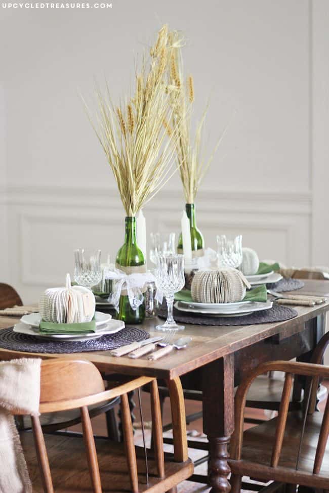 Green glass vases with dried wheat bouquets for rustic farmhouse table decor.