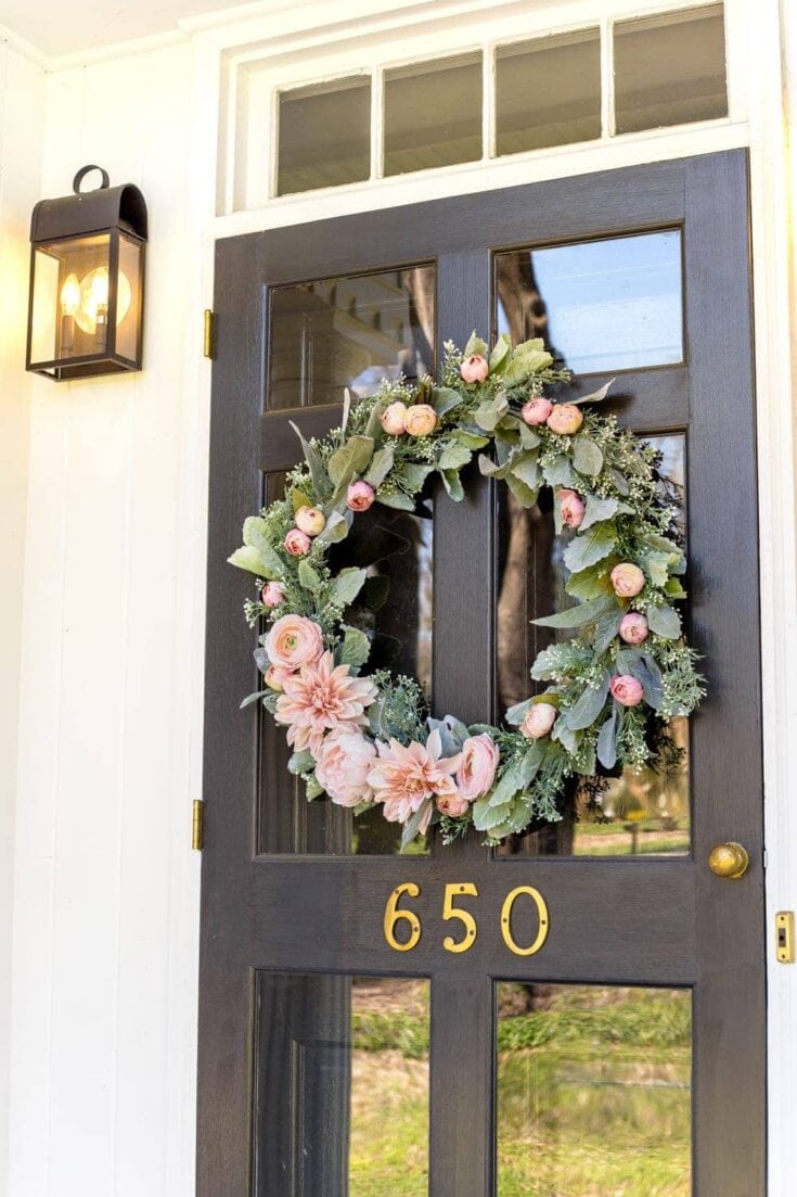 Blooming floral wreath hanging on front door with house number 650, perfect for outdoor decor and home styling.