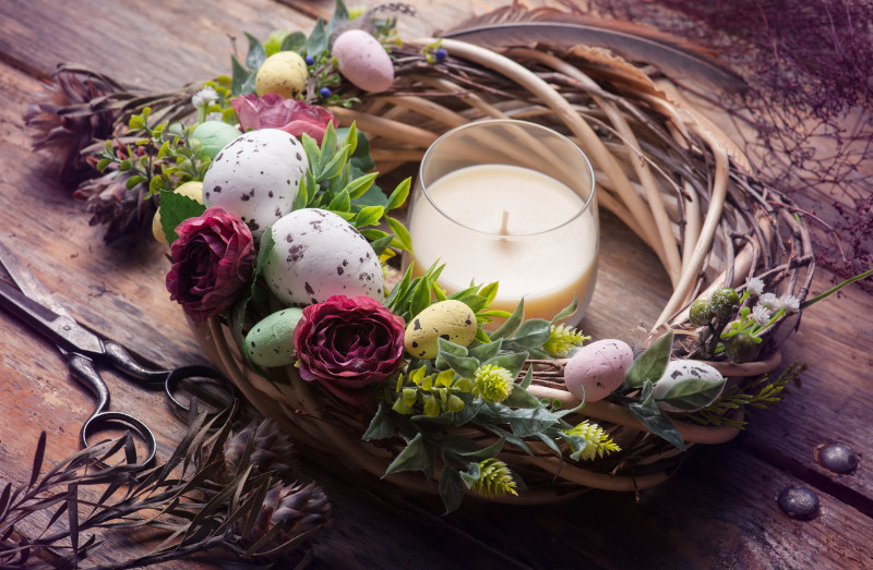 exposed wreath for with easter flowers and eggs with candle