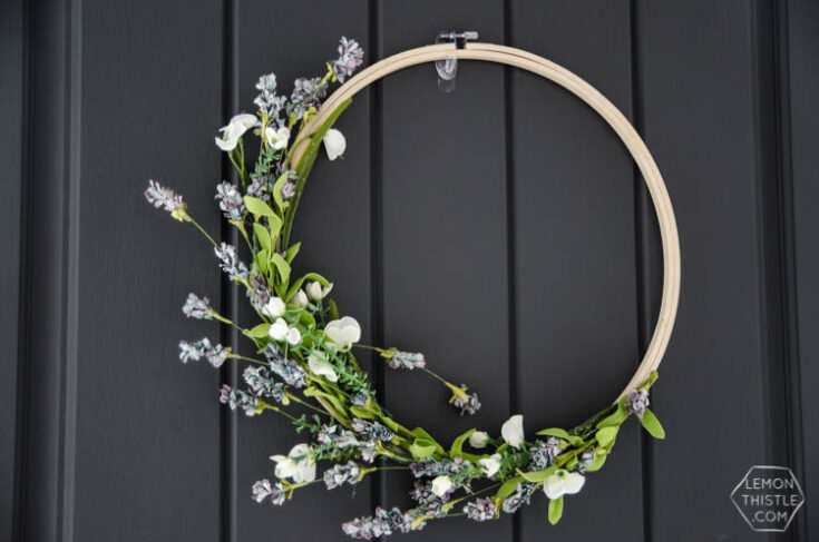 Elegant floral wreath with white and purple blossoms, perfect for home décor or special occasions, displayed on a black door.