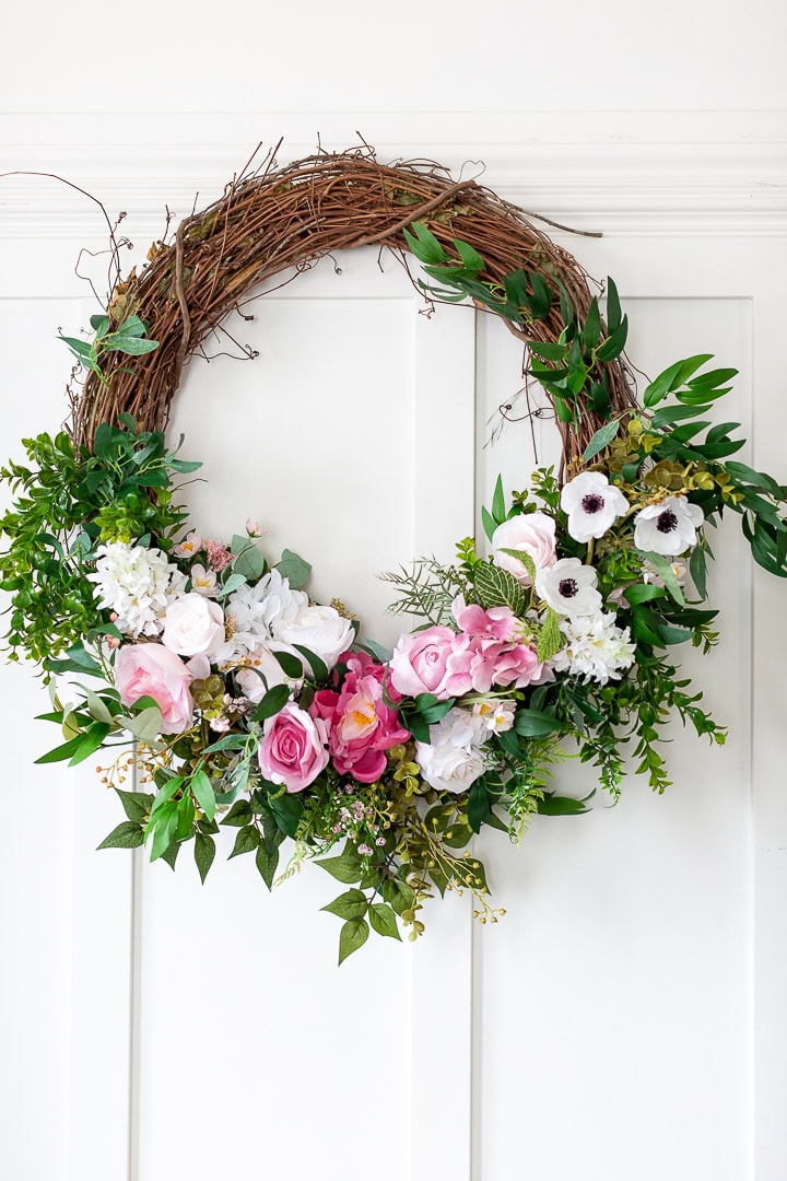 Vintage spring floral wreath with pink roses, white anemones, eucalyptus leaves, and greenery on white door, ideal for spring or Easter home decor, floral decor, wreaths, wedding decoration.
