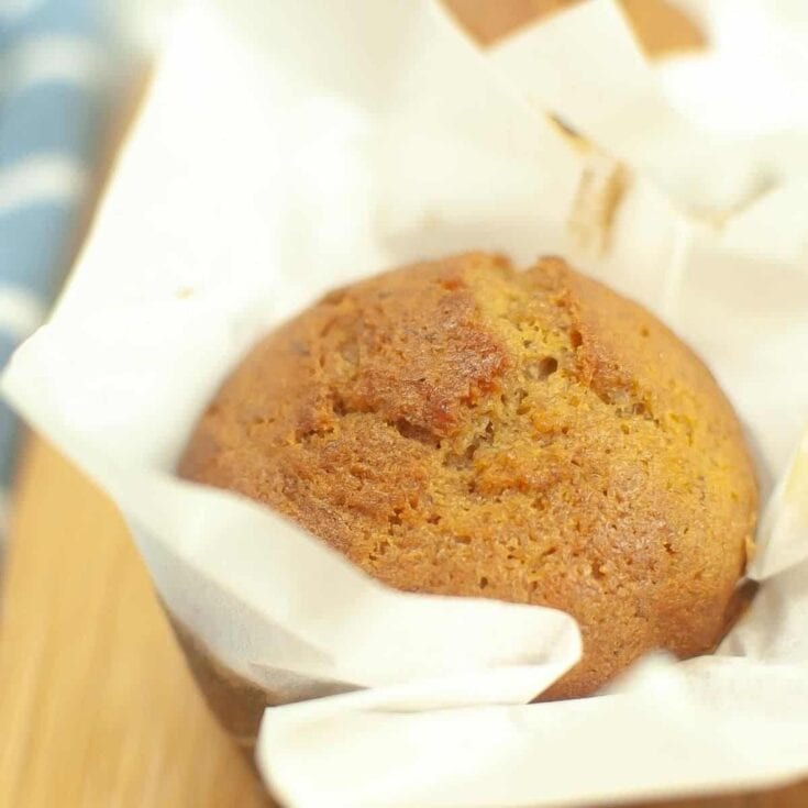 Soft banana muffin in paper cupcake liner with golden brown crust, fresh baked, homemade bakery treat, ideal for breakfast or snack, perfect for gifting or everyday indulgence.