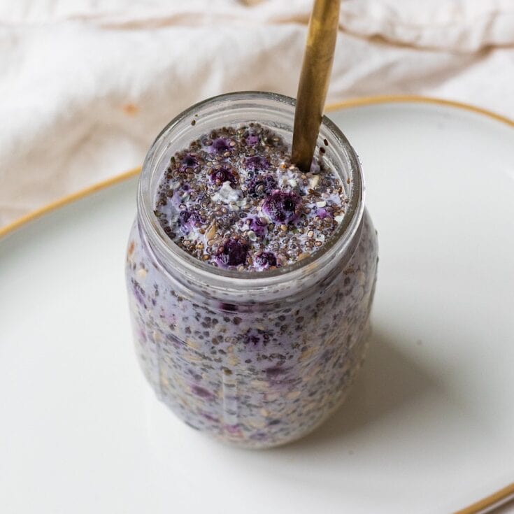 Fresh blueberry smoothie in a glass jar with a metal straw, topped with whole blueberries and chia seeds. Perfect for a healthy, delicious breakfast or snack.