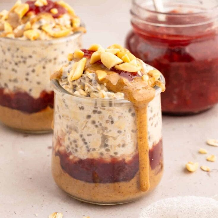 Creamy layered dessert with chia seeds, fruit preserves, and crunchy nuts in glass jars, perfect for healthy snacks or easy desserts.