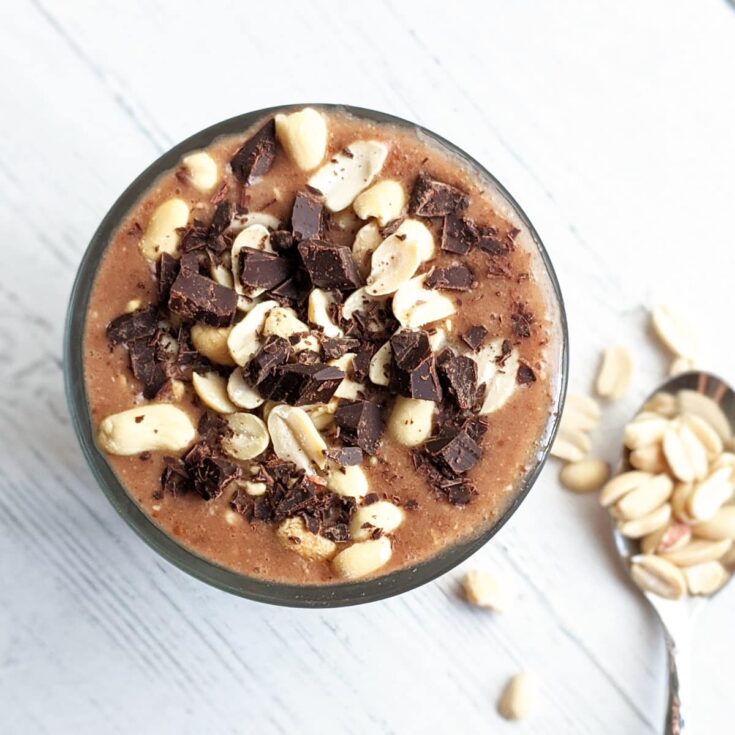 Creamy chocolate peanut butter smoothie topped with chopped dark chocolate and white chocolate chips, served in a glass. Perfect for a delicious, indulgent breakfast or snack.