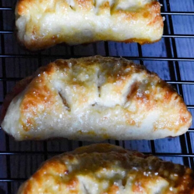 Golden cheesy calzones fresh out of the oven, crispy on the edges with gooey melted cheese inside, perfect for satisfying comfort food cravings.