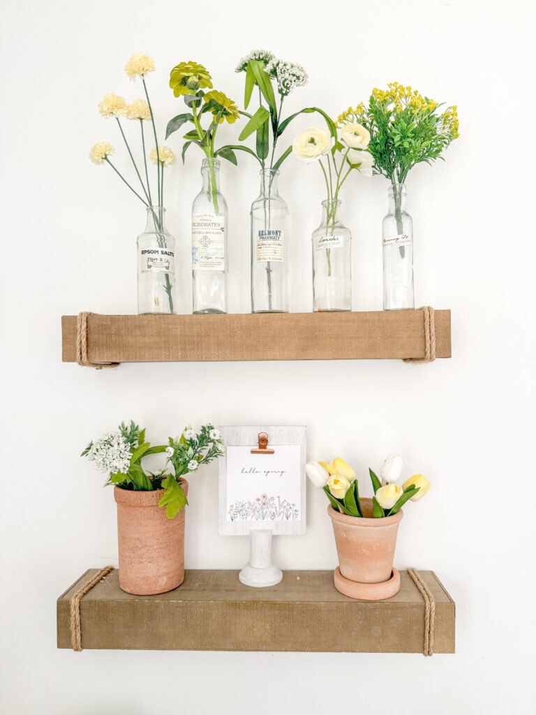 floating shelves with green and yellow faux flowers, terra cotta pots with faux tulips, hello spring tulip sign