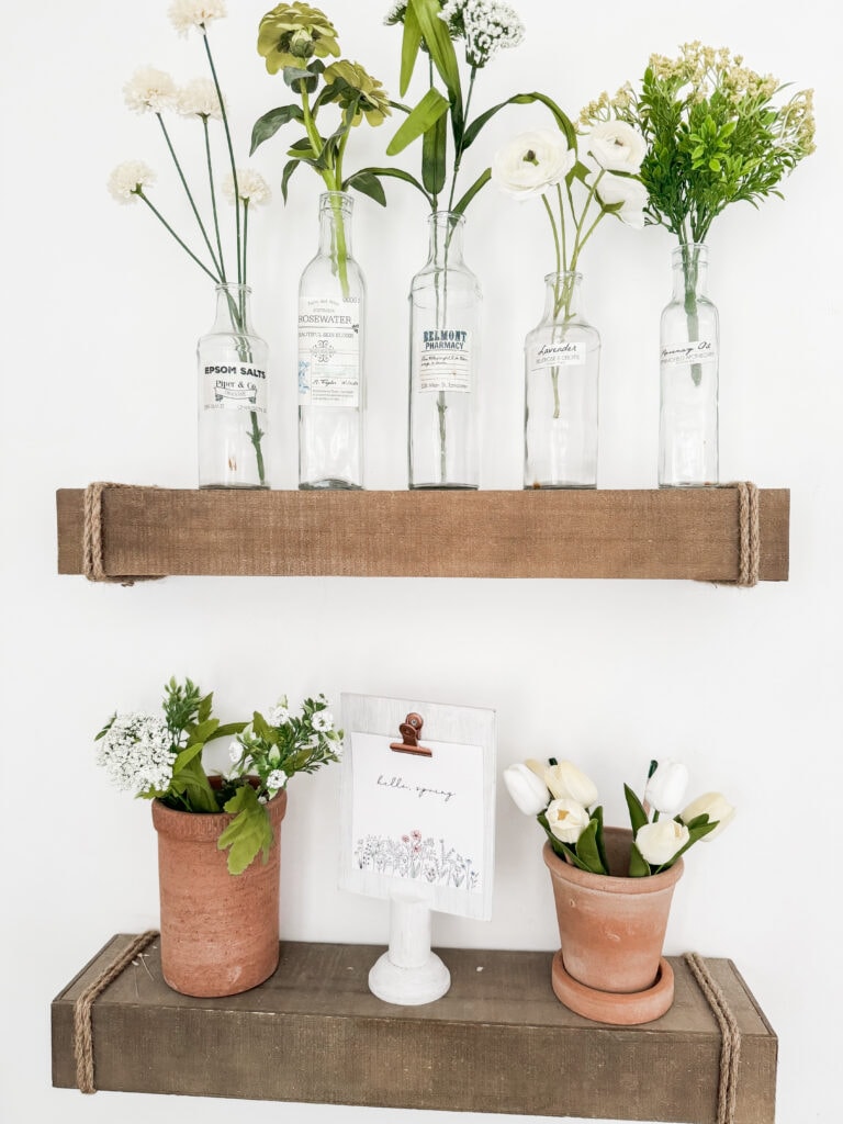 floating shelves with green and yellow faux flowers, terra cotta pots with faux tulips, hello spring tulip sign