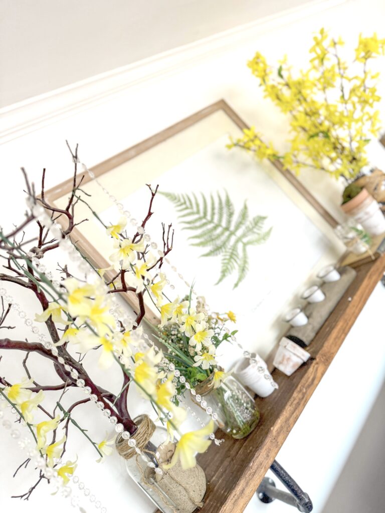 shelf with manzanita tree, rhinestones, faux florals dripping, fern wall art, faux forsythias and garden decor