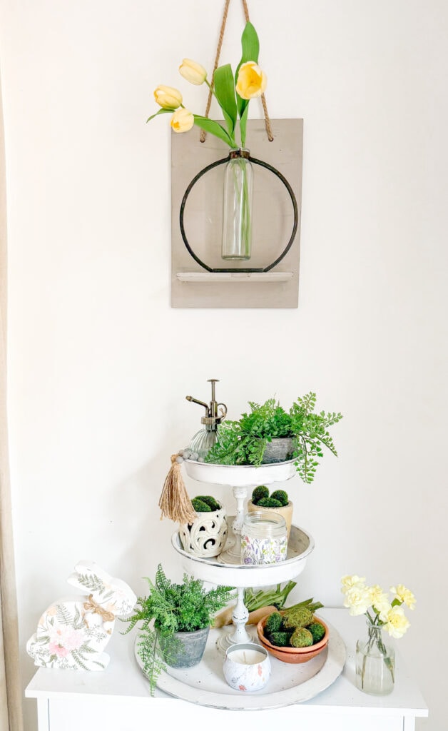 spring tiered tray with spring garden decor with tulips in magnolia test tube vase on shelf above