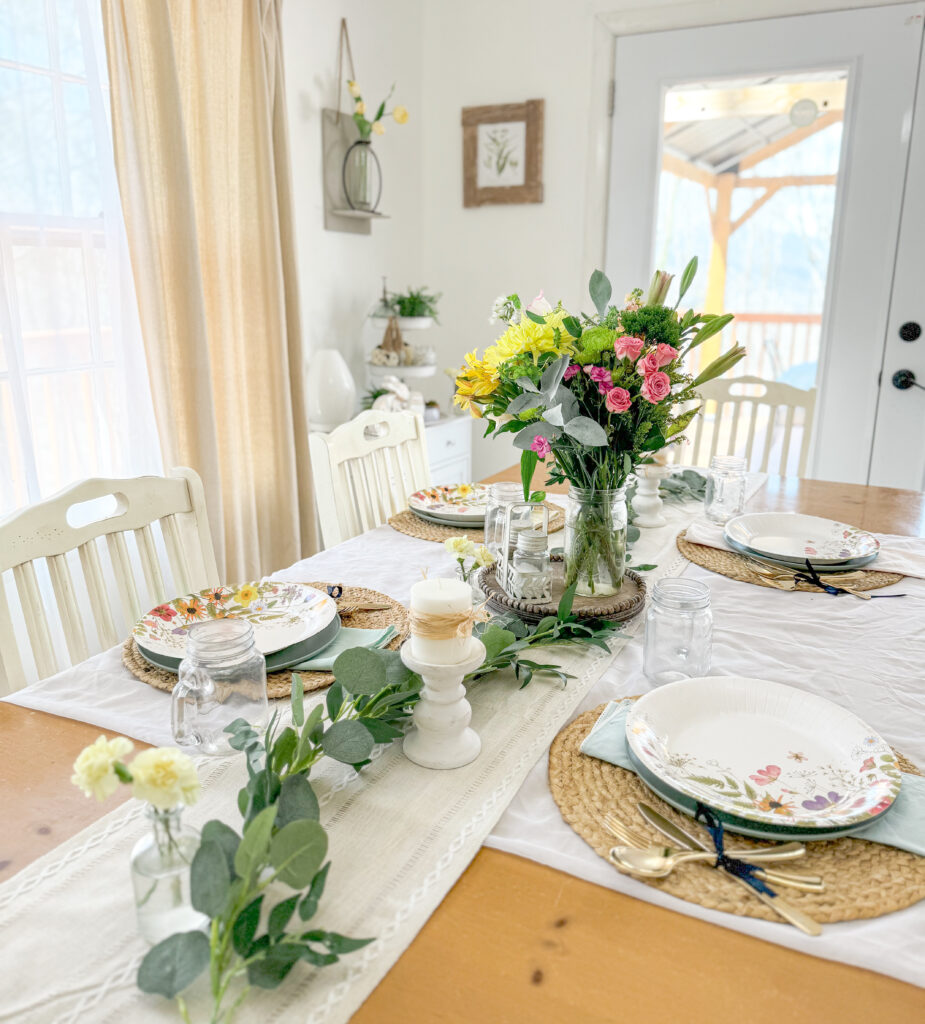 spring table with flower centerpiece and wildflower paper plates