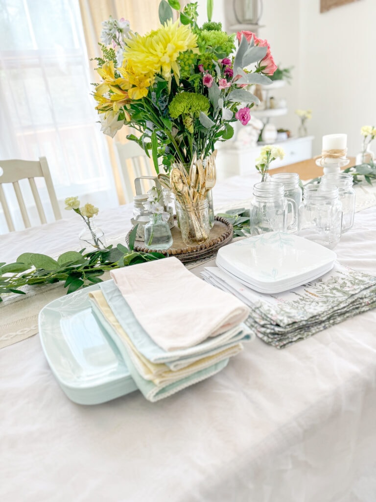 spring centerpiece of fresh floral flowers with plates, mason jar glasses, wildflower and pastel linen napkins