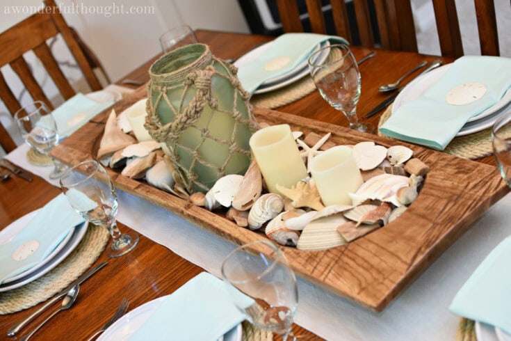 coastal beach themed summer table scape with seashells and nautical lantern