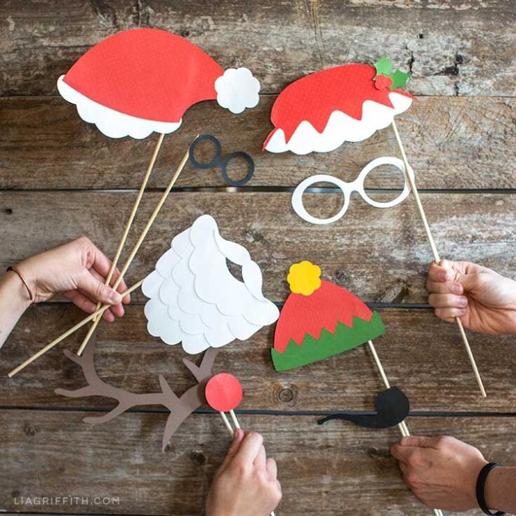 Santa hat photo booth props on rustic wooden background for Christmas party fun and holiday photo booth accessories. Perfect for festive celebrations and creating memorable holiday photos.