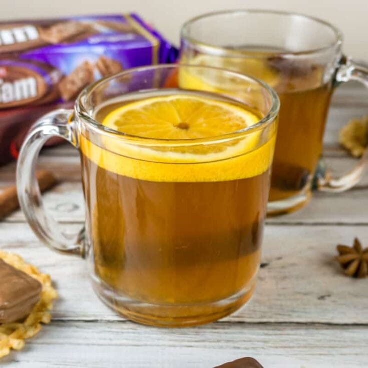 Warm holiday spiced tea with lemon slices in clear glass mugs, cozy and inviting for autumn or winter comfort drinks, perfect for festive gatherings or relaxing moments.