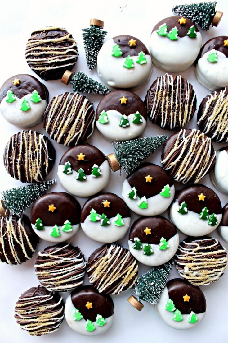 Decorated Christmas cookies with holiday-themed icing, sprinkles, and miniature Christmas tree toppers on a white background.