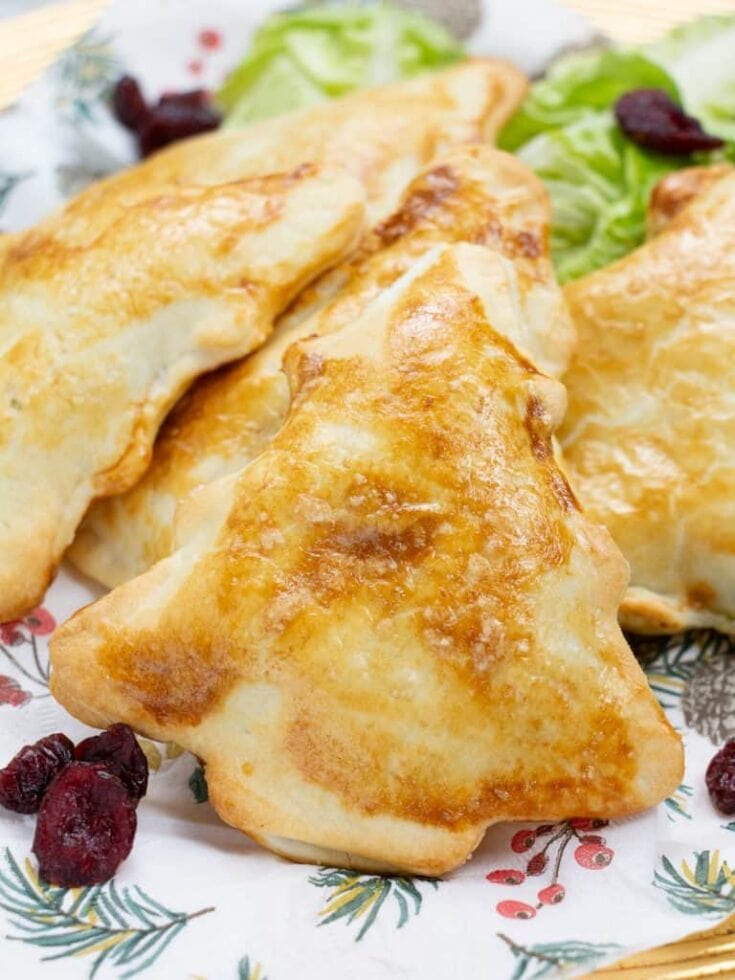 Freshly baked cheese-stuffed crescent rolls served with cherry cranberries on a holiday-themed plate, featuring a golden-brown crust and crispy edges, perfect for festive gatherings.