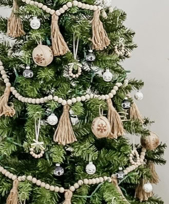 Decorated Christmas tree with wood and bead ornaments, tassels, and seasonal accents for holiday home decor and festive celebrations.
